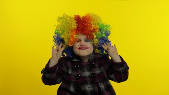 Little Child Girl Clown in Colorful Wig Making Silly Faces. Having Fun, Singing, Dancing. Halloween