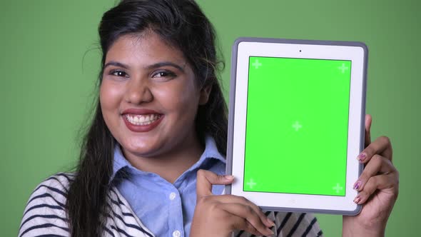 Young Overweight Beautiful Indian Businesswoman Against Green Background