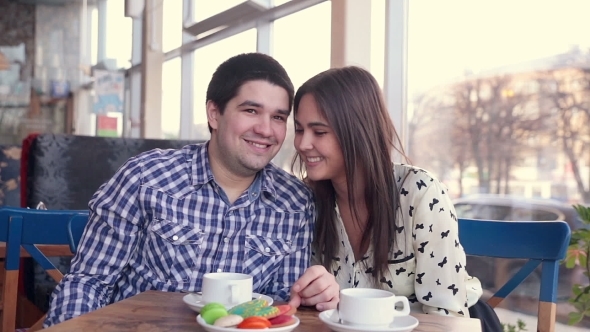 Happy Loving Couple In Cafe Laughing, Drinking Tea. Using Tablet For Fun. First Date. 