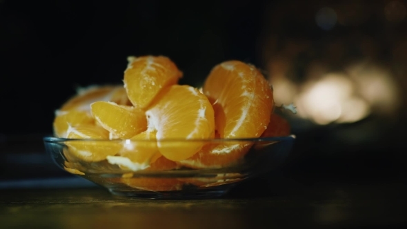 Tangerine Slices Are on The Plate on a Background of Fire