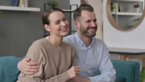 Happy Couple Having Conversation While Sitting on Sofa