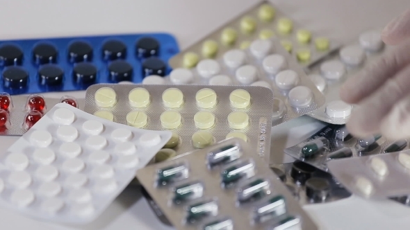 Male Hand Holding a Pack Of Medicine Tablets