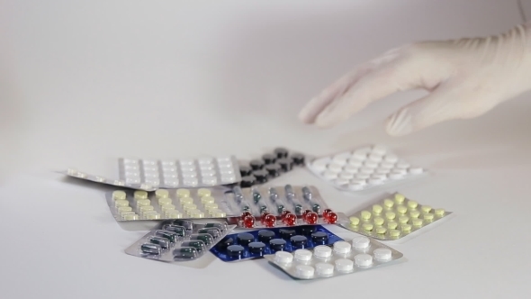 Male Hand Holding a Pack Of Medicine Tablets