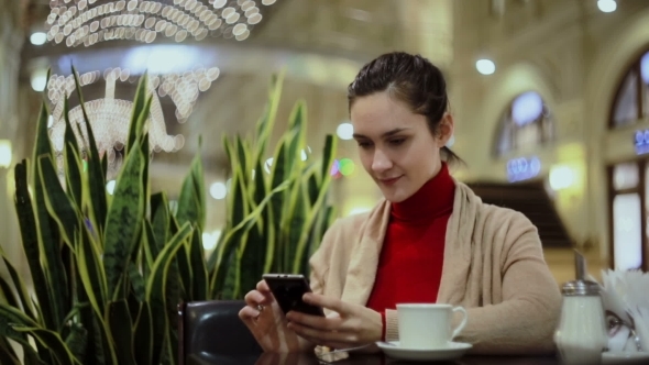 Woman Using Smartphone, Drinking Coffee In Cafe. 