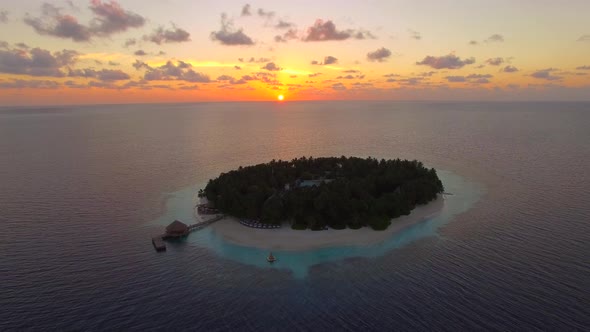 Aerial drone view of scenic tropical islands at sunset in the Maldives.