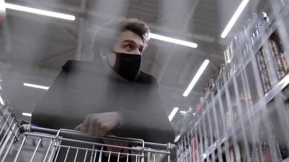 Young Attractive Man with Face Mask Standing in Supermarket