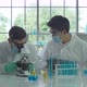 Asian Scientist working on blue test tube to analysis and develop vaccine of covid-19 - VideoHive Item for Sale