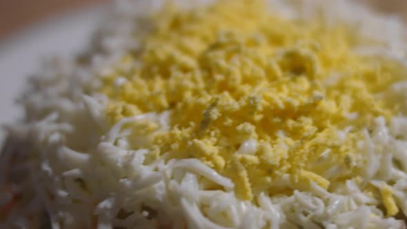 Olivier Salad on a White Plate Decorated with Grated Egg