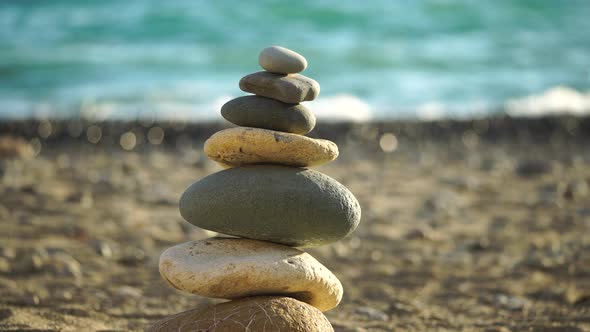 Balanced Pebbles Pyramid on the Beach on Sunny Day and Clear Sky at Sunset