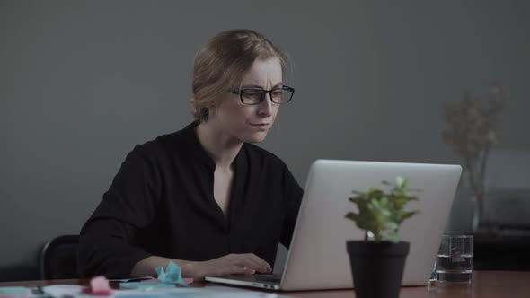 Unhappy Angry Young Woman Sitting at Her Desk in Front of the Computer