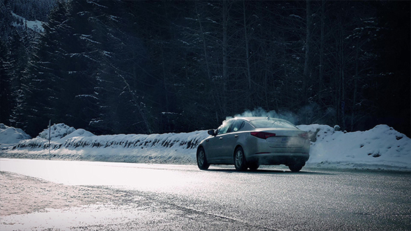 Steaming Car Drives Through Snowy Landscape