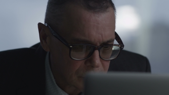 Elderly Businessman Working With Computer In Modern Office