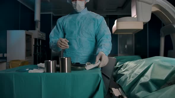 Adult Surgeon Prepares Tools for Surgery