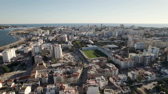 Portimão Aerial cityscape, Flying through Soccer Stadium surrounded by Residential Buildings