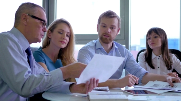 Boss Showing His Employees a Document In Office Discussion