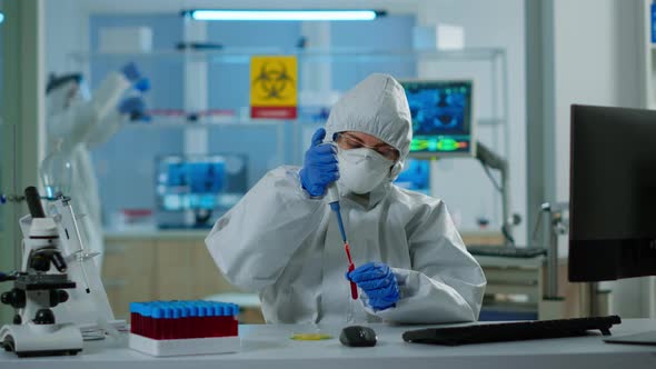 Science Technician in Ppe Suit Using Micropipette and Petri Dish Analysing Blood Sample