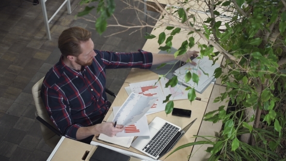 Man Looks At The Figures On Paper alt