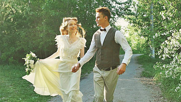 Young Beautiful Couple Walking In The Park Holding Hands