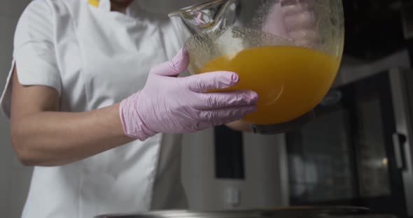 Confectionery is Pouring Honey Into a Bowl of Gingerbread Dough