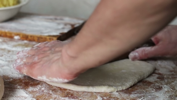 Woman Rolls The Dough With a Rolling Pin