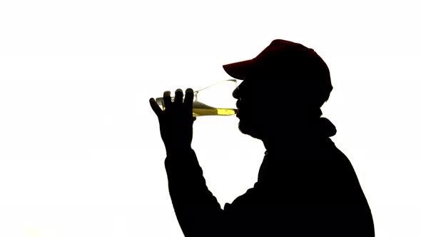Guy Drinks a Glass of Beer. Side View. Silhouette White Background