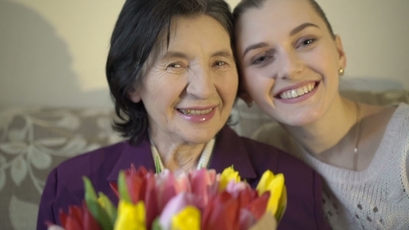 Gandmother With Flowers And Granddaughter