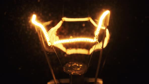 Tungsten Filament in a Glass Lamp Closeup in Slow Motion on Black Background