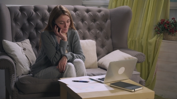 Young Girl Talking On The Smartphone, Making Notes On Charts And Laptop.