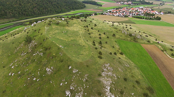 Aerial Footage of a Model Airplane on a Green Hill