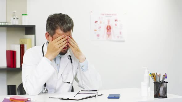 Tired Doctor in Medical Cabinet Taking Off the Glasses