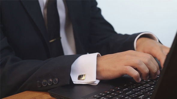 Man Typing on Laptop in Office. alt