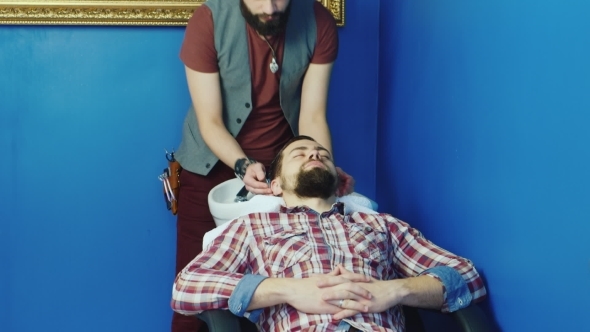 Young Bearded Man Washing His Head In Hairdressers