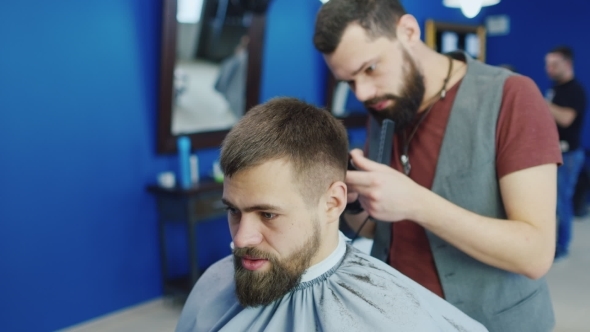 Barber Shave The Beard Of The Client With Trimmer 