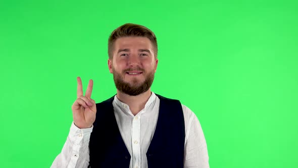 Man Shows Two Fingers Victory Gesture. Green Screen