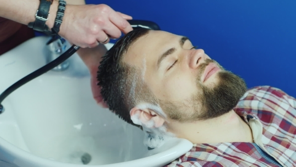 Man Barber Washing Male Hair In a Barbershop 