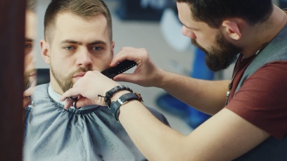 Men's Hairstyling And Haircutting In a Barber Shop Or Hair Salon. Grooming The Beard. Barbershop