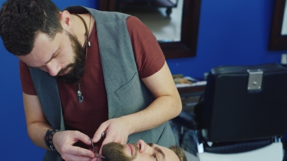 Men's Hairstyling And Haircutting In a Barber Shop Or Hair Salon. Grooming The Beard