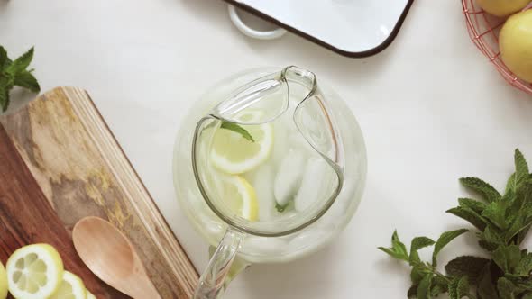 Step by step. Preparing traditional lemonade with fresh sliced lemons and mint.