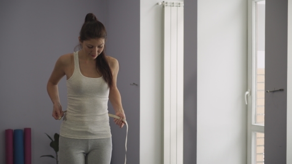 The Girl Measures The Waist In The Gym. alt