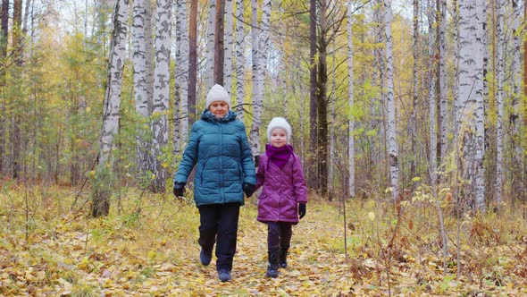 Grandmother with Granddaughter Going in Forest