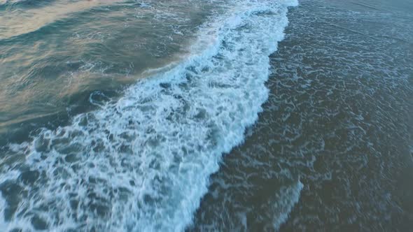 Aerial shot of waves breaking on the beach.