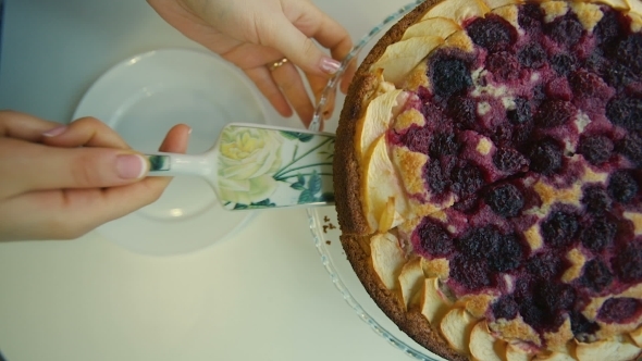 Woman Puts a Piece of Cake on a Plate