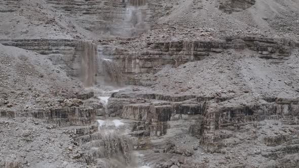 Aerial Fly Over powerful muddy waterfall after a flood in Israel Judean Desert