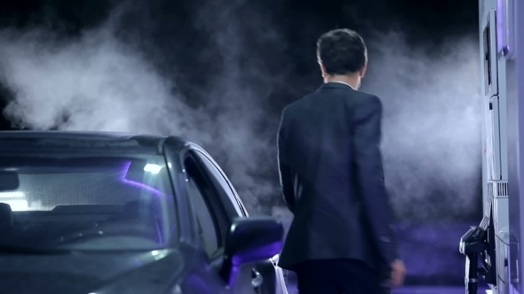 Businessman Filling a Vehicle With Fuel alt