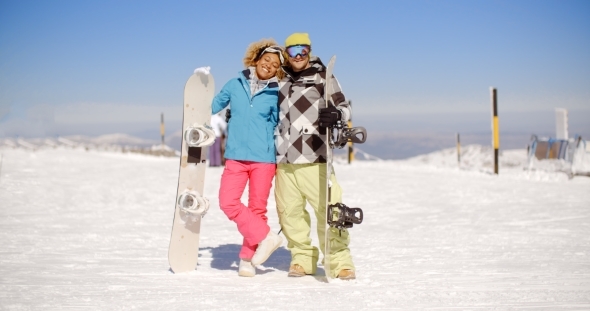 Happy Young Couple Posing With Their Snowboards
