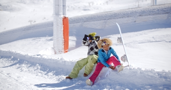 Young Couple Getting Ready To Go Snowboarding