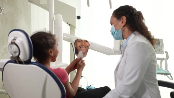 Smiling Girl Admiring Own Reflection at Dentist