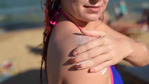 Portrait of a Beautiful Young Woman Smiling in a Bikini Smeared Face with Sun Protection Cream Sea