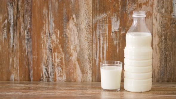 Glass and Bottle of Milk on Wooden Table