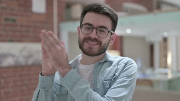 Portrait of Cheerful Young Male Designer Clapping